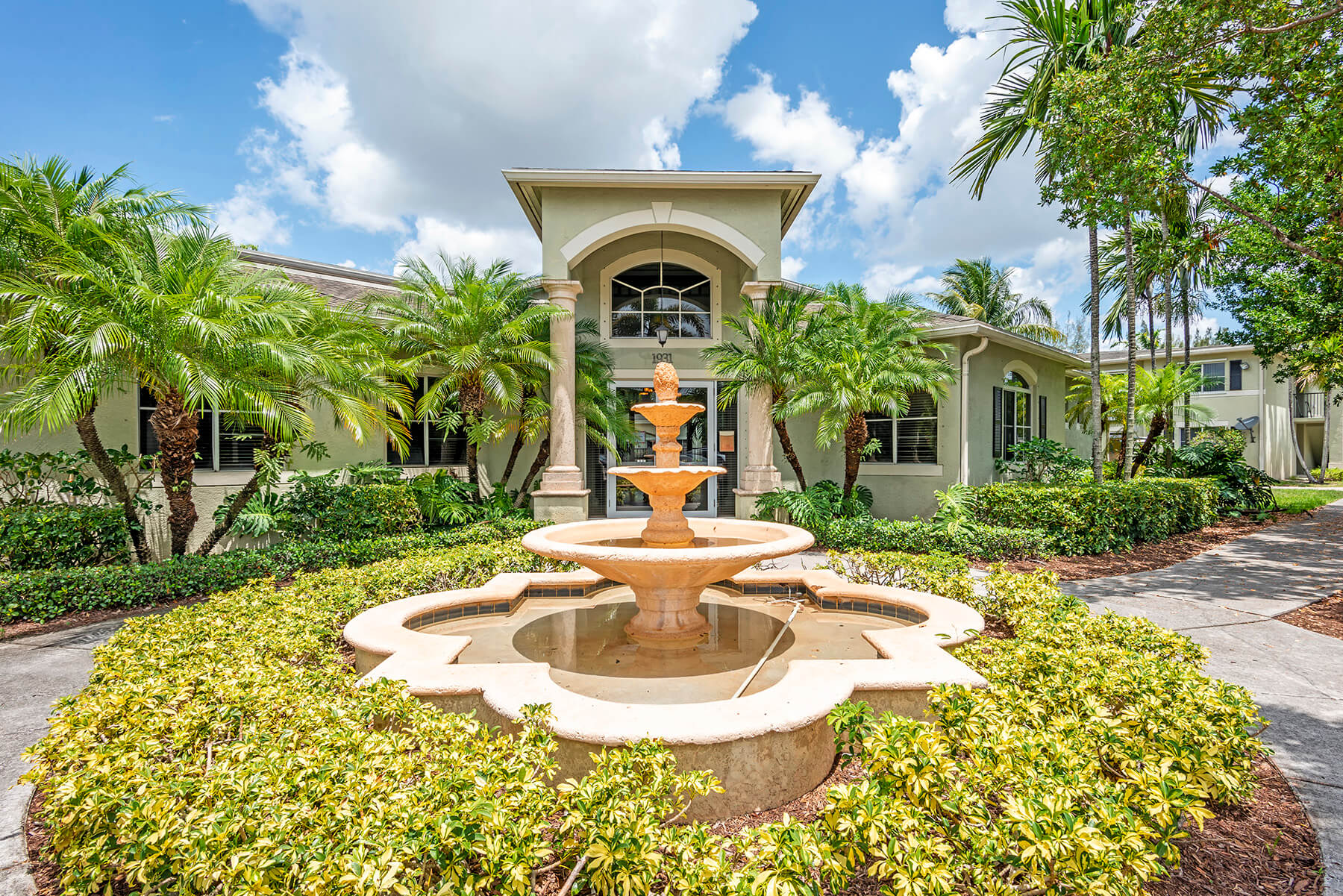 The building exterior and fountain sculpture of the leasing center at the Emerald Dunes Apartments in Miami, Florida.